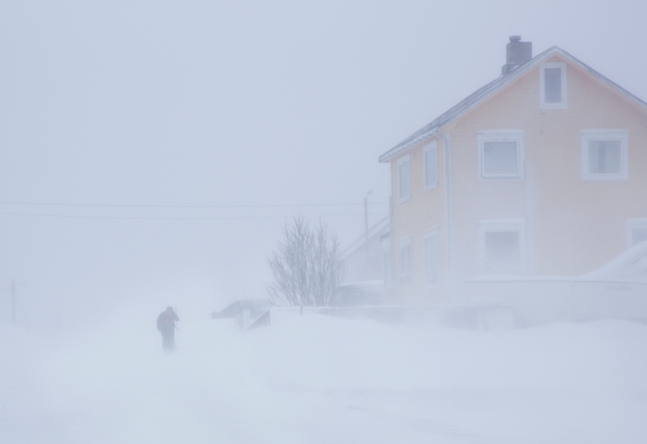 Gult hus i snøstorm. Foto. 