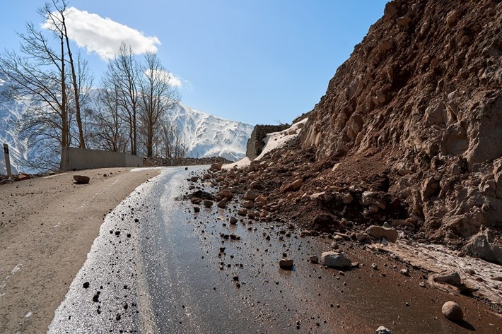 Jordskred med steiner som faller på bilveien
